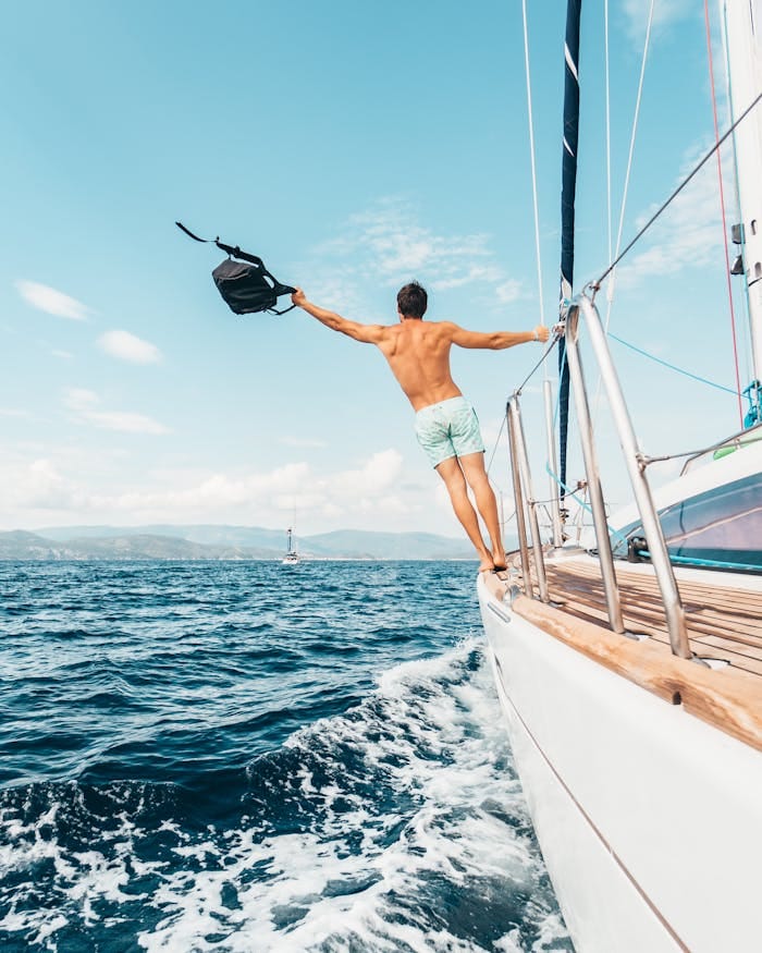 pexels photo 1223649 Man enjoying freedom by jumping into the ocean from a sailboat in Greece.